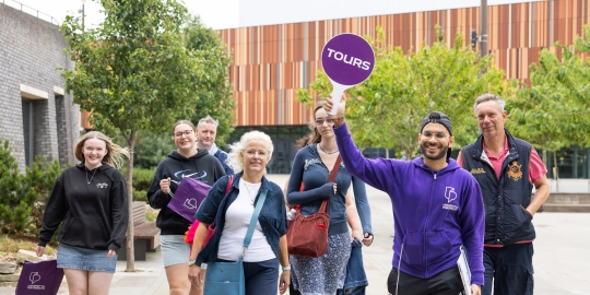 A student ambassador from the University of Portsmouth leading a group on a campus tour