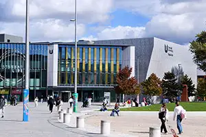 Teesside University campus showing Student Life and Digital Life buildings with students walking and relaxing outdoors